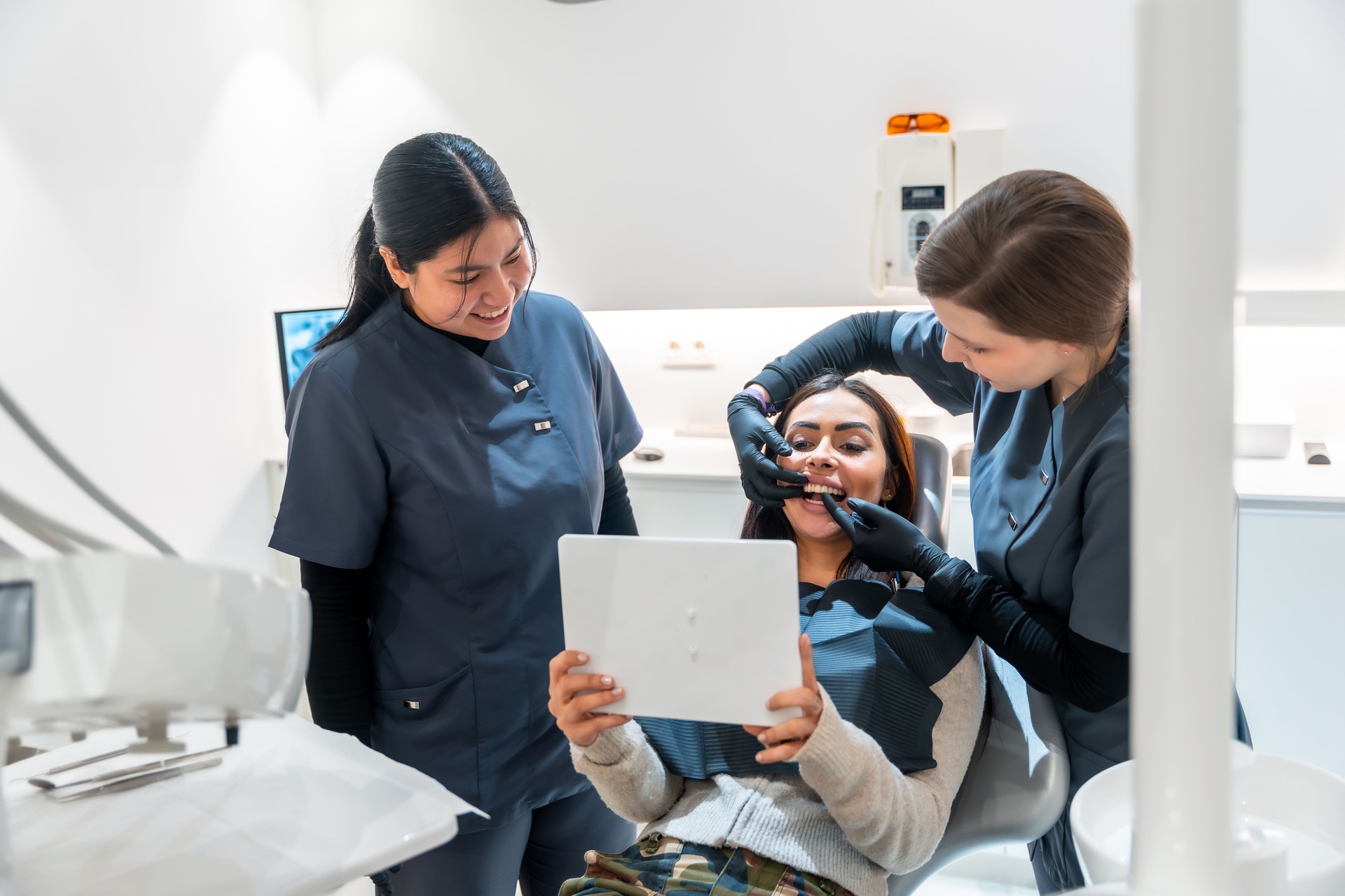 Dentist showing teeth whitening results to patient in modern clinic